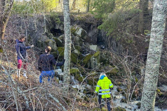 – Sääli, kun näkee, miten nopeasti tilanne täällä on mennyt pahemmaksi. Vesi on syönyt maata pois ja sillan kivirakenne on päässyt murtumaan. Mutta äkkiähän vesi syö, tutkija Sanna Saunaluoma (oik.) totesi siltavierailullaan. Ylempänä Turun museokeskuksen tutkija Sara Tamsaari ja ympäristönsuojelusihteeri Jonna Hostikka.